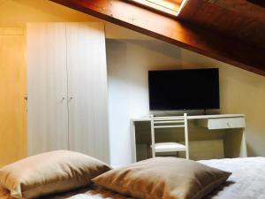 sypialnia z łóżkiem, biurkiem i telewizorem w obiekcie B&B Lanziani w mieście Nemoli