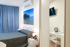 a small bedroom with a bed and a desk at Innmare Fortuna Hotel Dos Estrellas in Mar&iacute;n