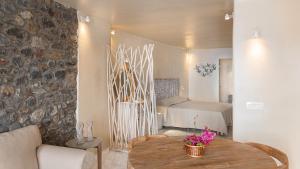 a living room with a table and a bedroom at Armeni Luxury Villas in Oia