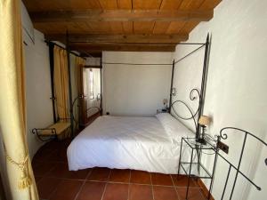 1 dormitorio con 1 cama blanca en una habitación en Casa Rural Azahara en Zahara de la Sierra