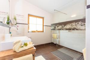 uma casa de banho com um lavatório e uma banheira em Landhaus Bergblick em Kössen