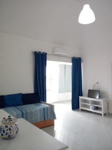 a bedroom with a bed and a window with blue curtains at da Letizia in Procida