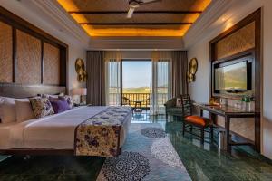 a bedroom with a king sized bed and a balcony at The Ananta Udaipur in Udaipur
