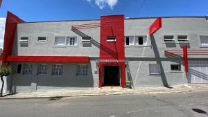 ein Gebäude mit einer roten Tür auf einer Straße in der Unterkunft Hotel dos Nobres in Poços de Caldas