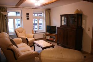 a living room with couches chairs and a tv at Ferienwohnung Altstadtnest Wernigerode in Wernigerode