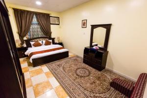 1 dormitorio con cama y espejo en العييري للوحدات المفروشة الباحة3, en Al Bahah