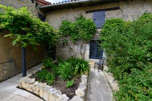 a stone house with a bench in front of a building at Chez Pique-Fesse Chambre d'hote in Saint-Martin-lʼArs