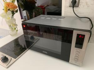 a microwave sitting on top of a counter at Joli studio tout confort avec toutes commodités in Vaulx-en-Velin