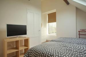 a bedroom with a bed and a flat screen tv at Vakantiewoning K&W NOT FOR COMPANIES in Ouddorp