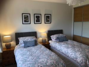 two beds sitting next to each other in a bedroom at Wisteria Cottages are self catering cottages in a beautiful village location in Dorrington