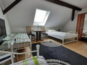 ein Schlafzimmer mit zwei Betten und einem Tisch und einem Fenster in der Unterkunft Pension Bei Valentina in Wertheim