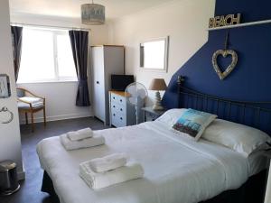 um quarto com uma cama grande e toalhas em The Sunfold em Weston-super-Mare