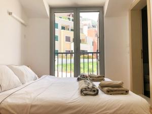1 cama con toallas y ventana en Lavender Bay Apartment D9, en Donji Morinj