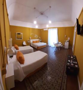 a hotel room with two beds and a table at B&B Kike in Catania