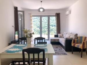 sala de estar con mesa, sillas y sofá en Lavender Bay Apartment D9, en Donji Morinj