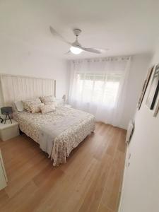 um quarto branco com uma cama e uma ventoinha de tecto em Tarragonaapartments Prim Reus em Reus