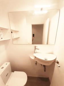uma casa de banho com um lavatório, um WC e um espelho. em Tarragonaapartments Prim Reus em Reus