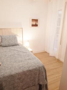 a white bedroom with a bed and a window at Tarragonaapartments Prim Reus in Reus