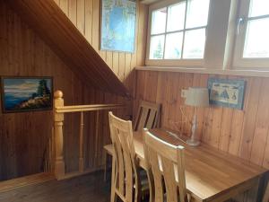 a dining room with a wooden table and chairs at Inkaro Kaimas in Nida