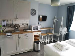 a small kitchen with a sink and a microwave at The Sunfold in Weston-super-Mare