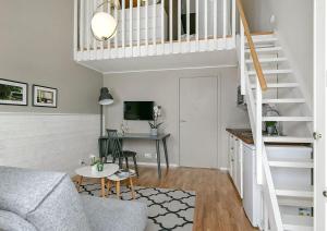 a living room with a couch and a staircase at Venngarn 304 in Sigtuna