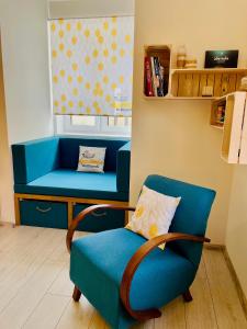 einen blauen Stuhl und eine Bank in einem Zimmer in der Unterkunft Apartmán Kežmarok in Kežmarok