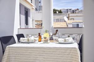 a table with plates and glasses on a balcony at Casas Sul in Burgau