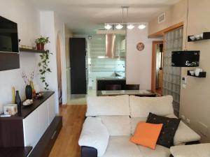 ein Wohnzimmer mit einem weißen Sofa und einer Küche in der Unterkunft ARUNDA-SUR in Ronda