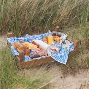 una cesta de picnic llena de comida y pan en la playa en Zeeuwse Zot en Wissenkerke