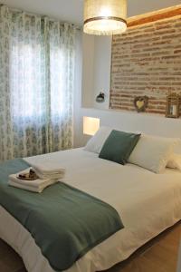 Un dormitorio con una gran cama blanca y una ventana en Muro de Cervantes, en Logroño