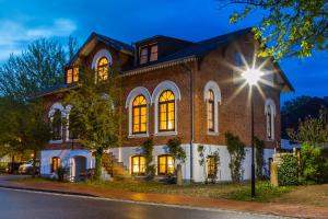 テニングにあるSmukkegård - historisch Wohnen im modernen Ambienteの灯り付きの大きなレンガ造りの家
