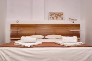 a large bed with white sheets and pillows on it at Starry Coast Apartments in Nea Potidaea