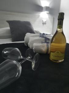 a bottle of wine and glasses on a table with a bed at Aedes Tropea B&B in Santa Domenica