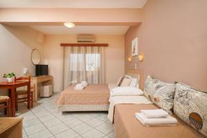 a hotel room with two beds and a television at Hotel Makrina in Skala Potamias