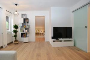 ein Wohnzimmer mit einem Flachbild-TV an einer weißen Wand in der Unterkunft Ferienwohnung Innsbruck-Vill in Innsbruck