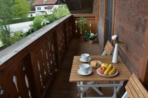 Una mesa de madera con un plato de fruta en un balcón. en Ferienwohnung Innsbruck-Vill, en Innsbruck