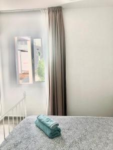 ein Bett mit einem grünen Handtuch in einem Schlafzimmer in der Unterkunft Alisios Dream in Corralejo