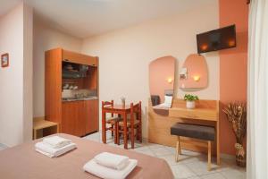 a room with a bed and a desk and a kitchen at Hotel Makrina in Skala Potamias
