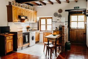 a kitchen with wooden cabinets and a table in it at La Rectoral in Beloncio