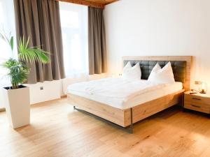 sypialnia z dużym łóżkiem z białą pościelą w obiekcie APARTMENTS zum Wohlfühlen MARIAZELL w mieście Mariazell
