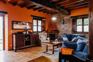 a living room with a blue couch and a fireplace at La Rectoral in Beloncio