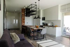 a kitchen and living room with a table and a couch at nauticaluxapartamenty.pl in Giżycko