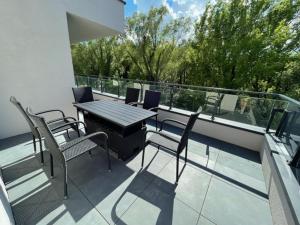 a patio with a table and chairs on a balcony at Lakeside Family & Studio Apartments in Keszthely