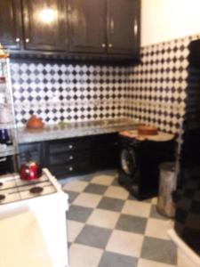 a kitchen with a black and white tiled floor at Appartement Maroc Safi in Safi