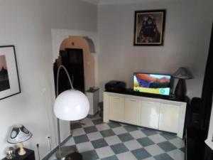 a living room with a television and a table with a lamp at Appartement Maroc Safi in Safi