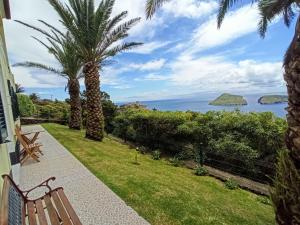 a patio with a bench and a view of the ocean at Casa das Merces in Angra do Heroísmo
