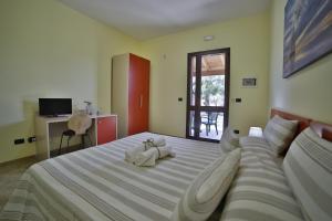 um quarto com uma cama grande e 2 toalhas brancas em B&B La Casa di Attilio em Punta Prosciutto