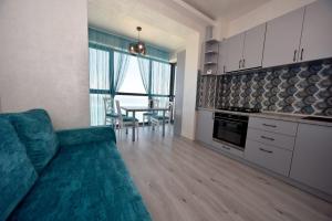 a living room with a couch and a kitchen with a table at Turquoise by the sea in Constanţa