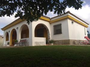 チクラナ・デ・ラ・フロンテーラにあるFig Tree Cottageのアーチと庭のある白い大きな建物