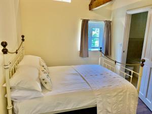 a white bed in a room with a window at Willow House in Hereford